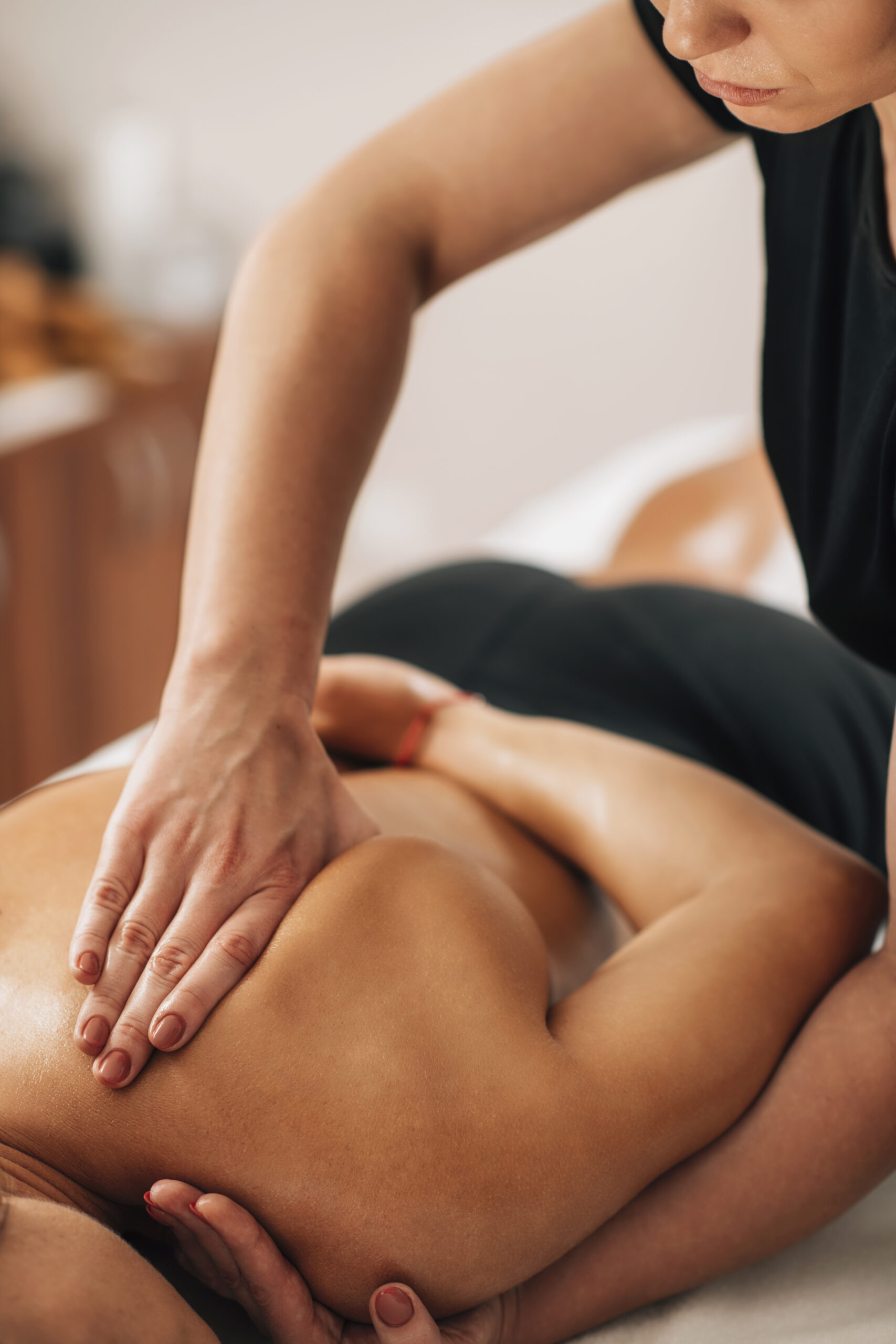 Relaxing neck and shoulder massage. Tanned woman enjoying neck and shoulder massage in a wellness center